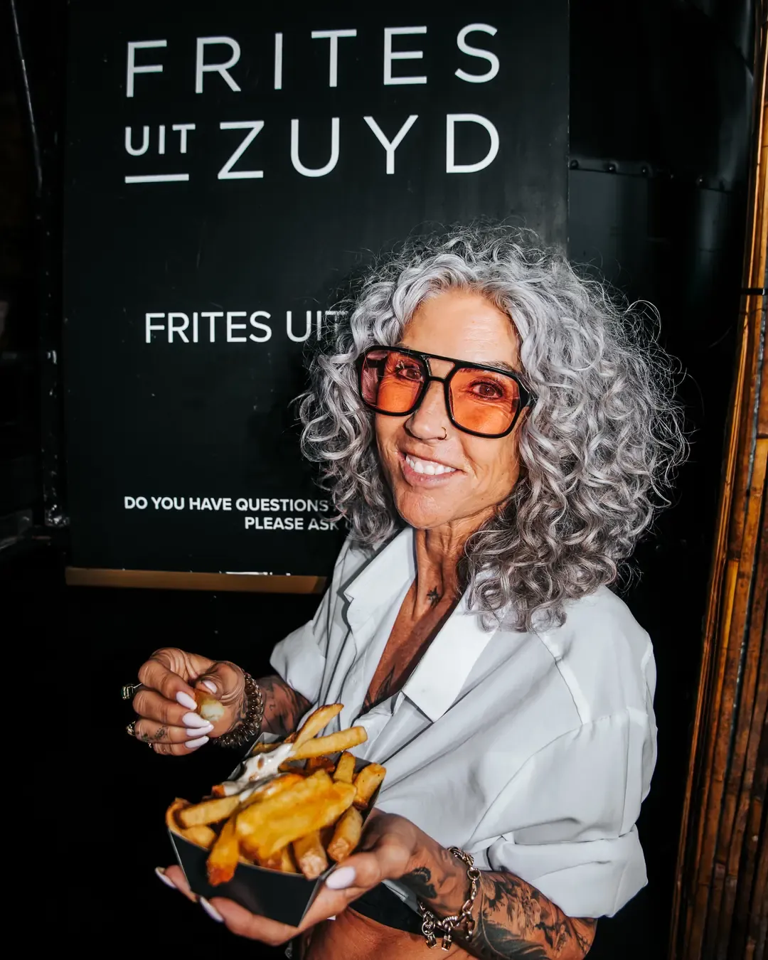 Bezoeker met frites voor het bord van Frites uit Zuyd